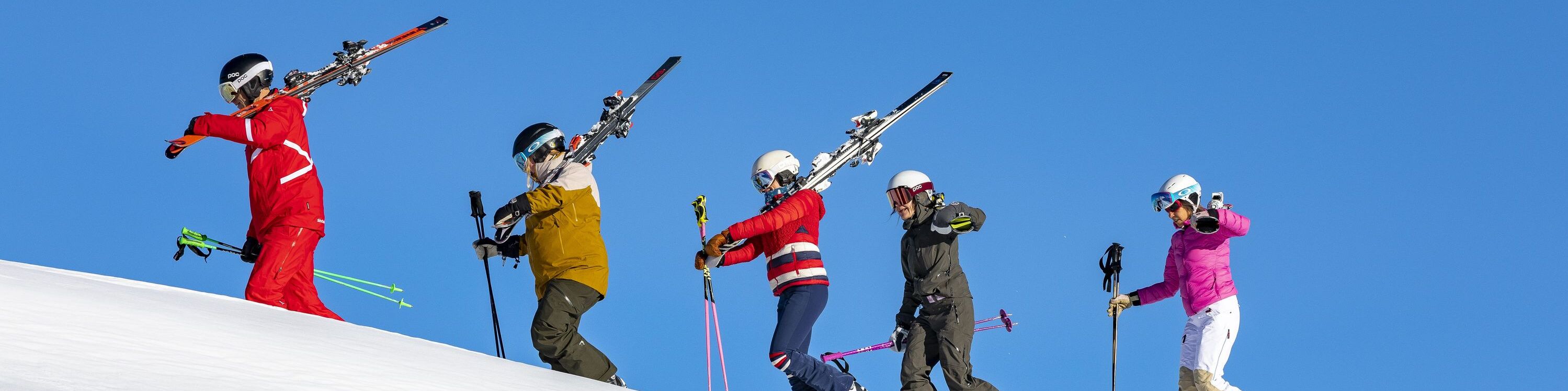 Gruppenskikurs Skischule Hirschegg schultert Skier auf der Piste 