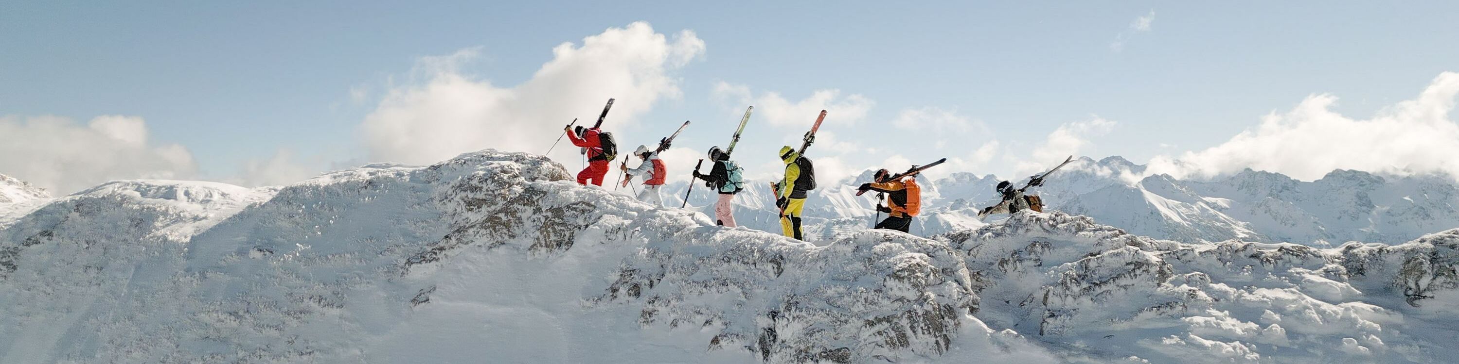 Skikurs schultert Skier hoch oben am Berg im Kleinwalsertal