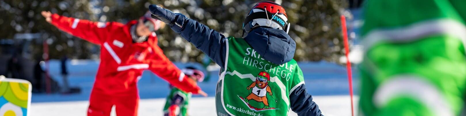 Ski instructor practises skiing with child in Kinderland Hirschegg