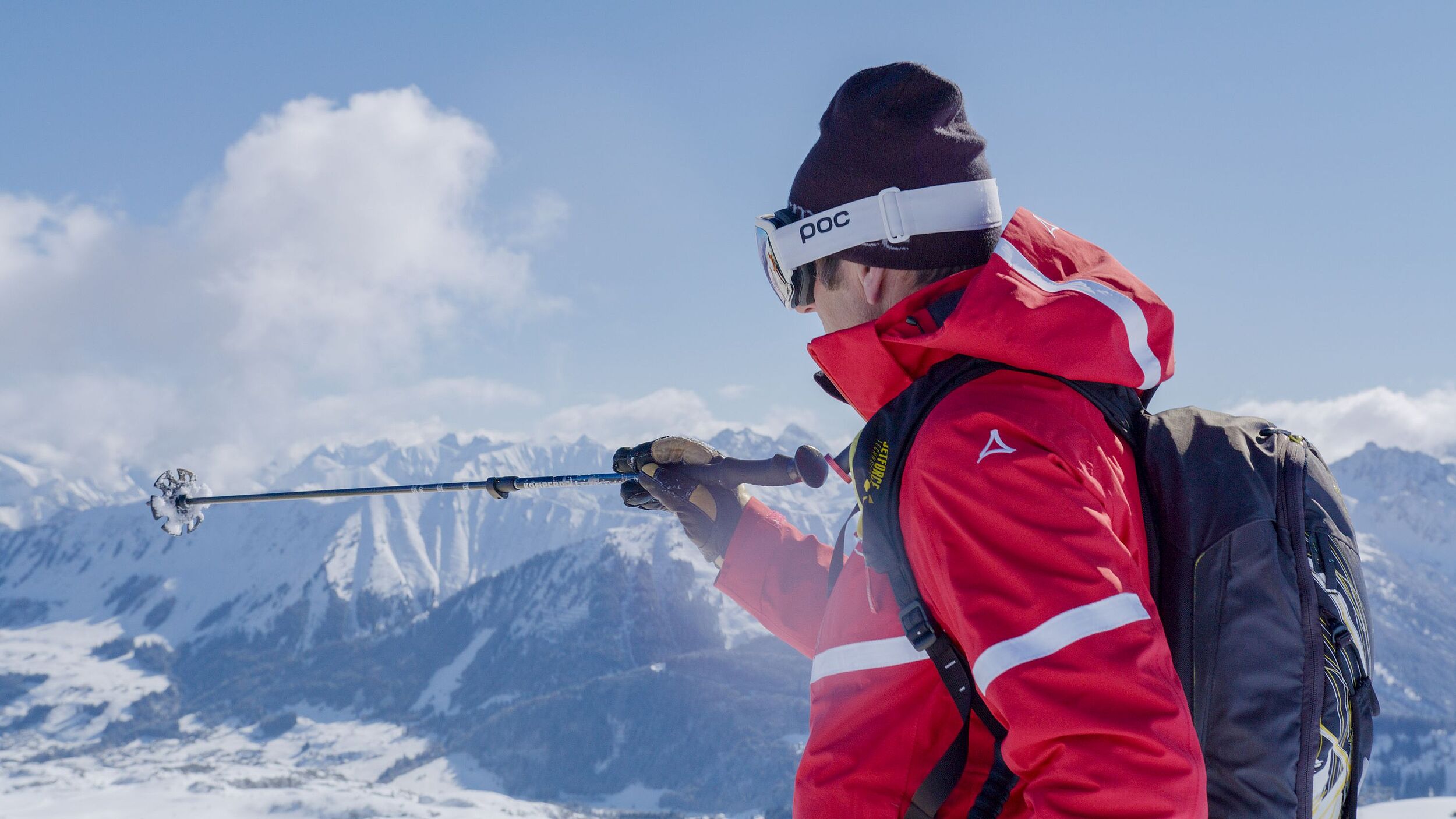 Skilehrer der Skischule Hirschegg zeigt in die Ferne mit Stock